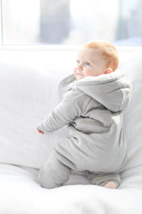 Baby's hand showing convertible covers on gray fleeced jumpsuit sleeve.