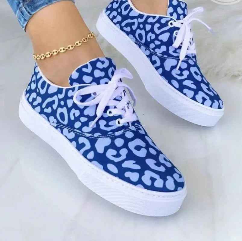 White women's sneakers with colorful graffiti-style designs on the sides, displayed against a plain background.