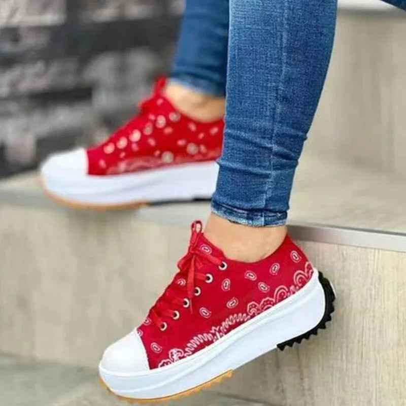 White canvas women’s sneakers with a colorful 2022 pattern, lace-up design, and flat rubber sole.