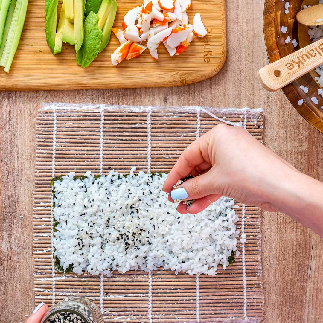 Sushi making kit with bamboo rolling mats and utensils arranged for easy sushi rolling.