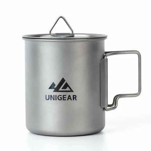 A lightweight titanium camping cup with folding handles, holding 450ml, shown standing upright on a table.