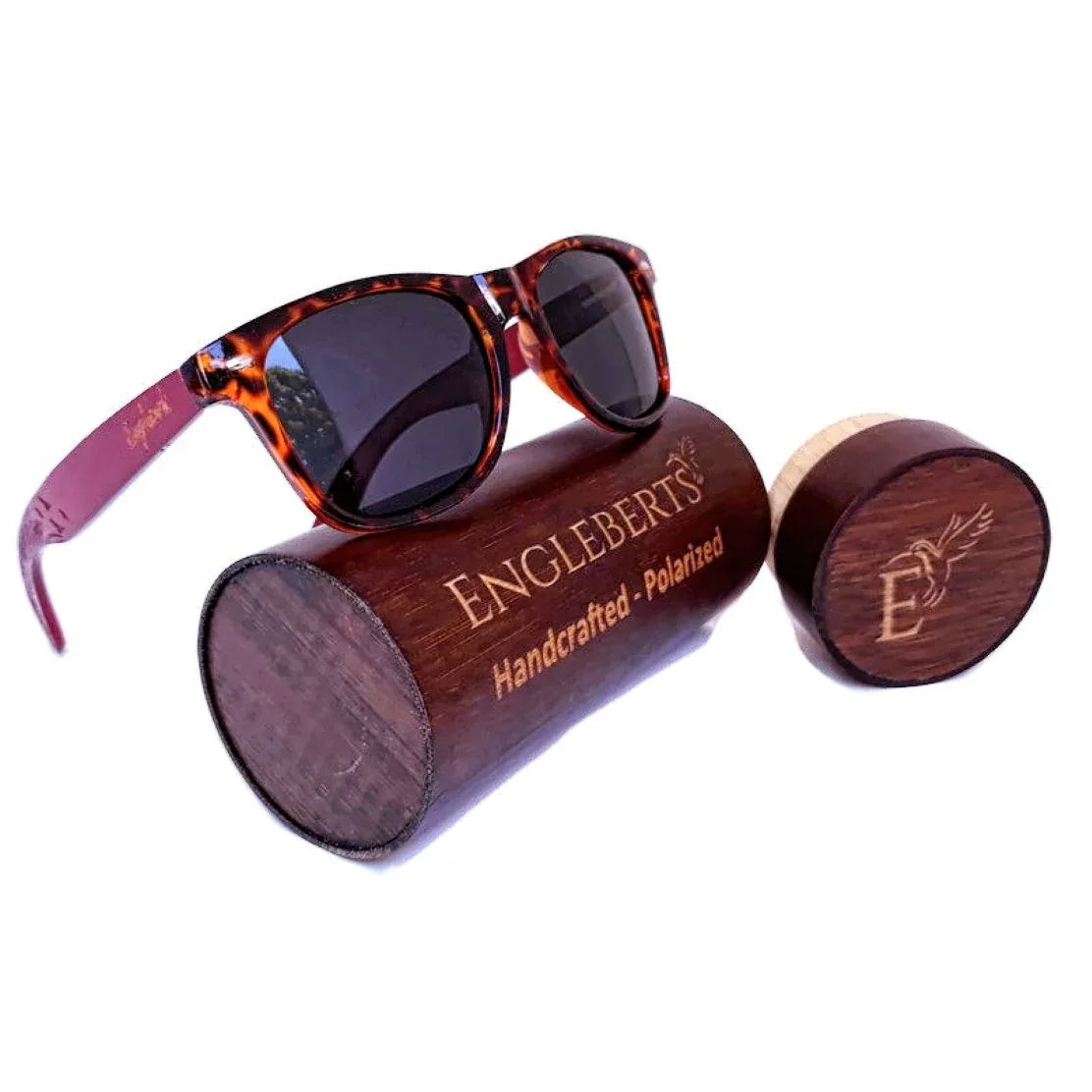 Red bamboo tortoise framed sunglasses with engraved wooden case on wooden surface.