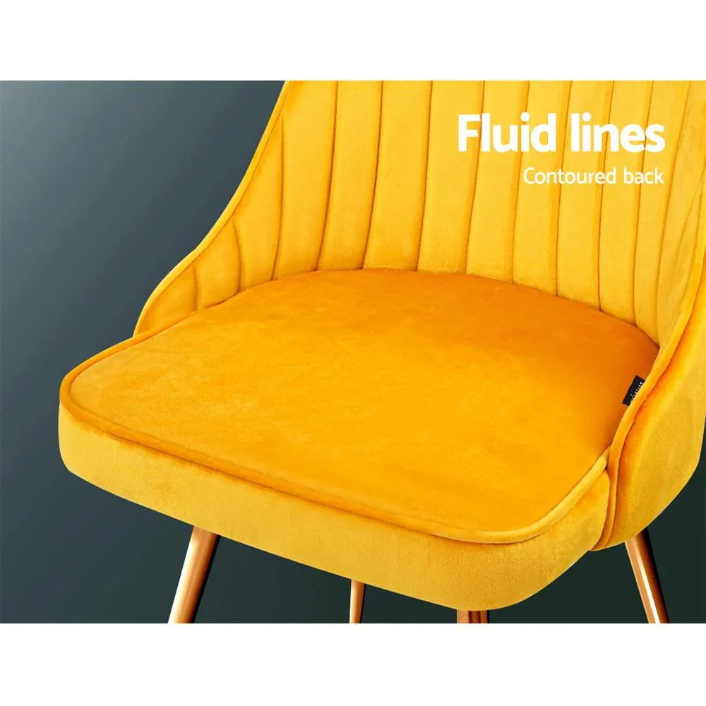 Two velvet Artiss dining chairs placed side by side showing luxurious seating and sturdy legs.