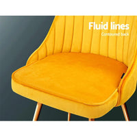 Two velvet Artiss dining chairs placed side by side showing luxurious seating and sturdy legs.