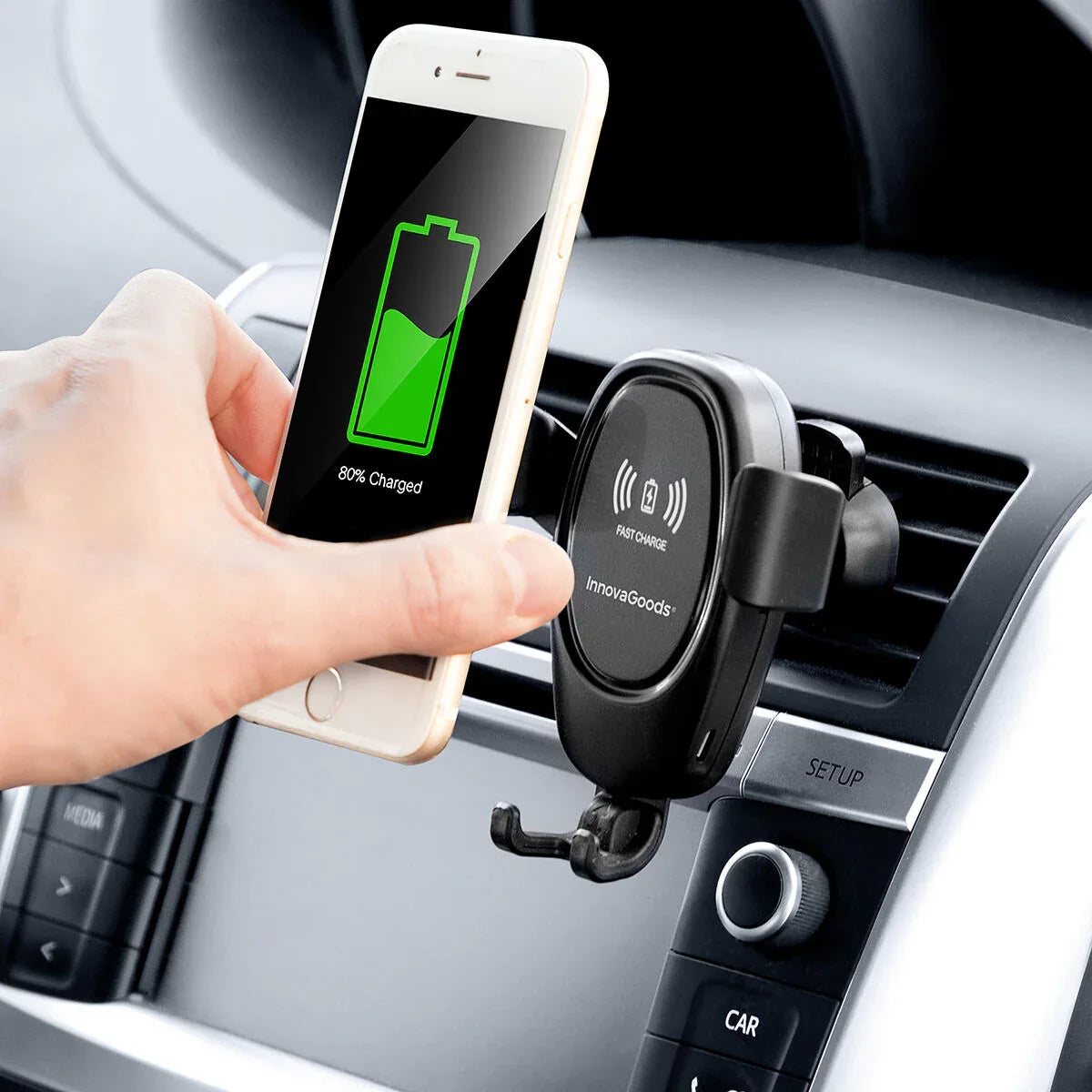 Mobile phone holder with wireless charging mounted on car dashboard, showing phone held securely.