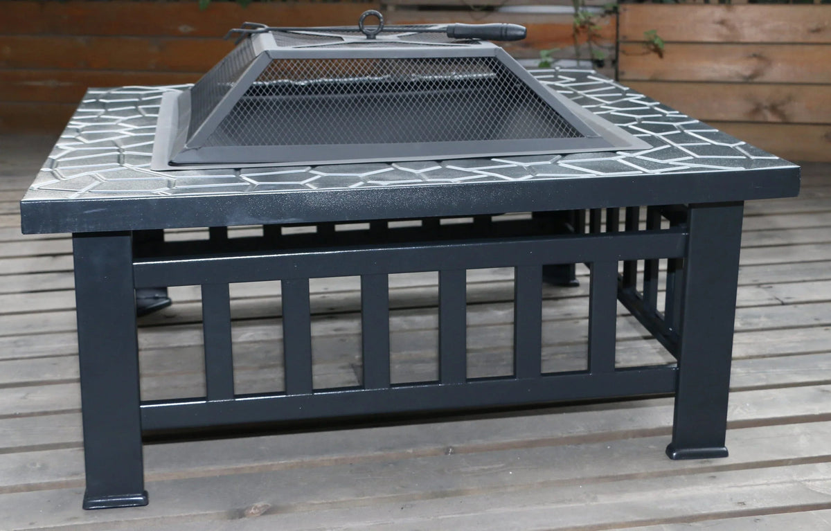 Fire pit shown outdoors on grass with barbecue cooking grate on top.