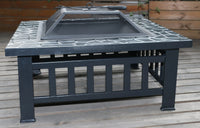 Fire pit shown outdoors on grass with barbecue cooking grate on top.