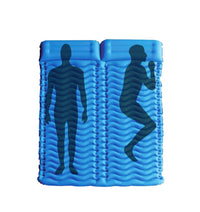 Compact air pump with hose attached next to deflated camping sleeping pad for quick inflation.