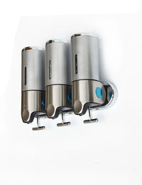 Close-up of the shower dispenser showing three refillable containers labeled for shampoo, conditioner, and body gel.