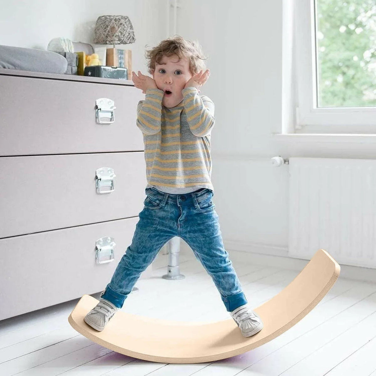 Curved wooden balance board on a white background, showing smooth solid beechwood surface