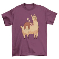 Front view of sleeping sloth riding llama graphic printed on a T-shirt in turquoise color.