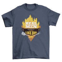 Black T-shirt laid flat featuring detailed BBQ grill illustration and 'Real Men smell like bbq' text.