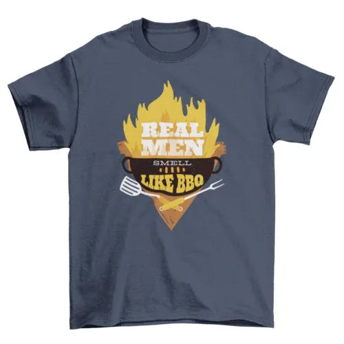 Black T-shirt laid flat featuring detailed BBQ grill illustration and 'Real Men smell like bbq' text.