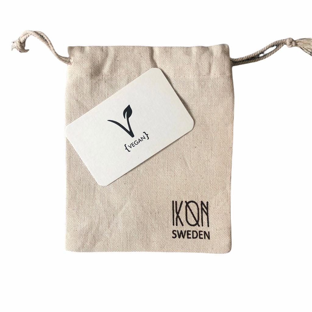 Hand holding dark grey coconut leather card holder highlighting size and texture.