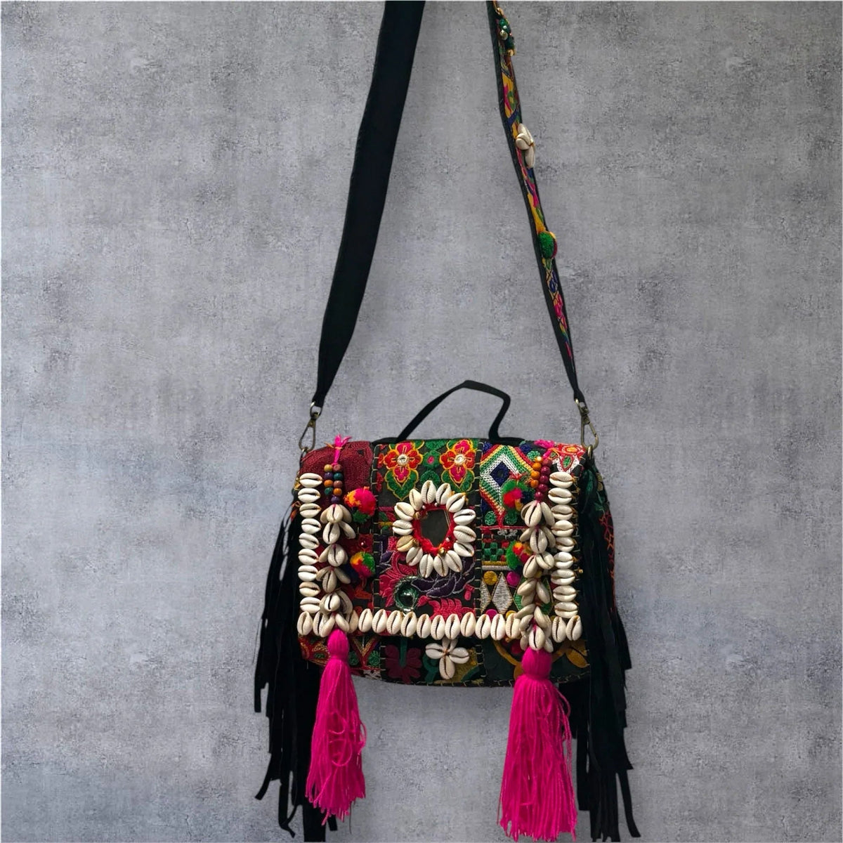 Close-up of the Banjara Boho Sling Bag center with large pink tassels, mirror accents, and detailed embroidery.