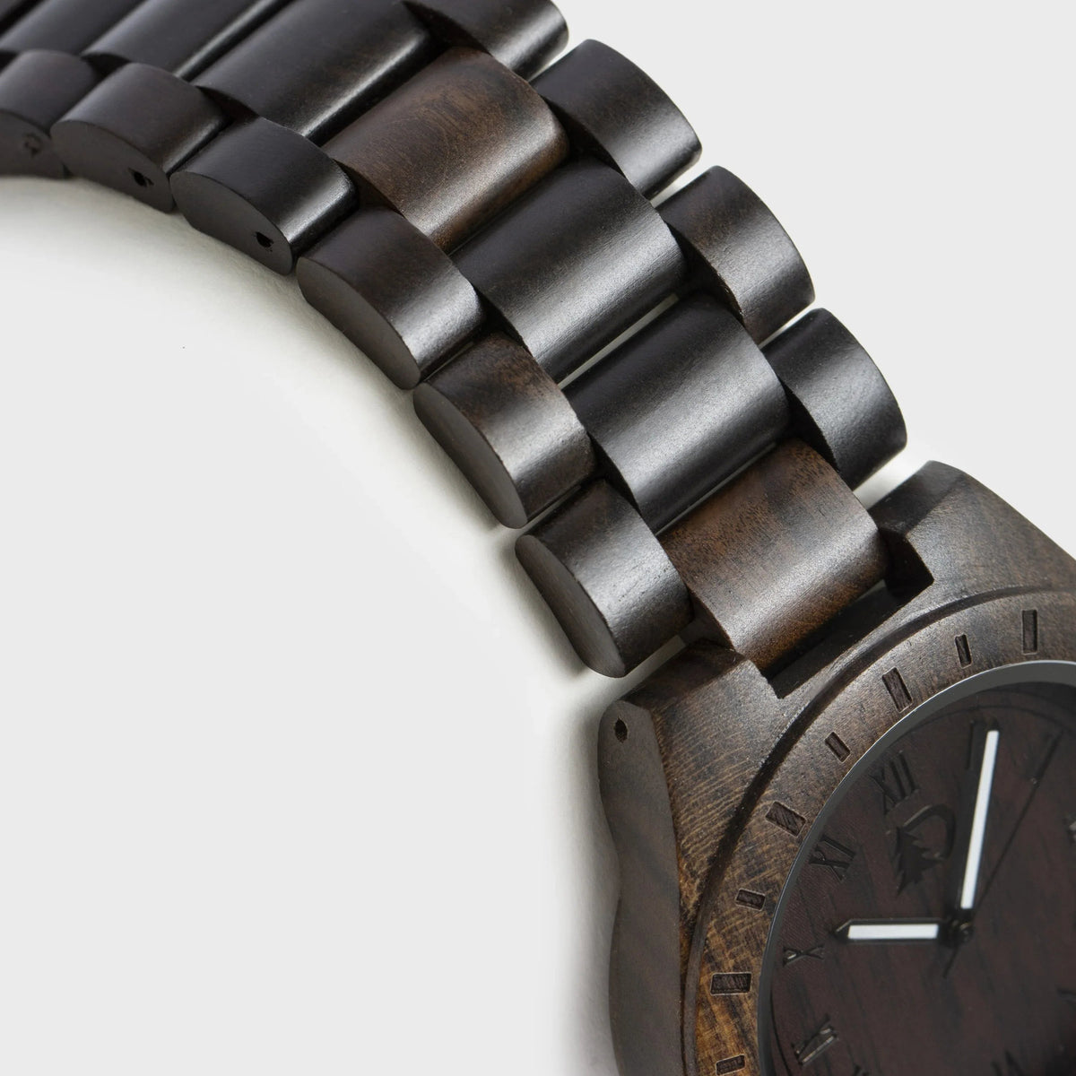 Men's wood watch displayed with textured black walnut face and silver details on wrist.