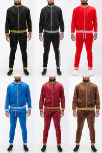 Male model wearing full zip status velour track jacket and matching pants, standing against a neutral background.