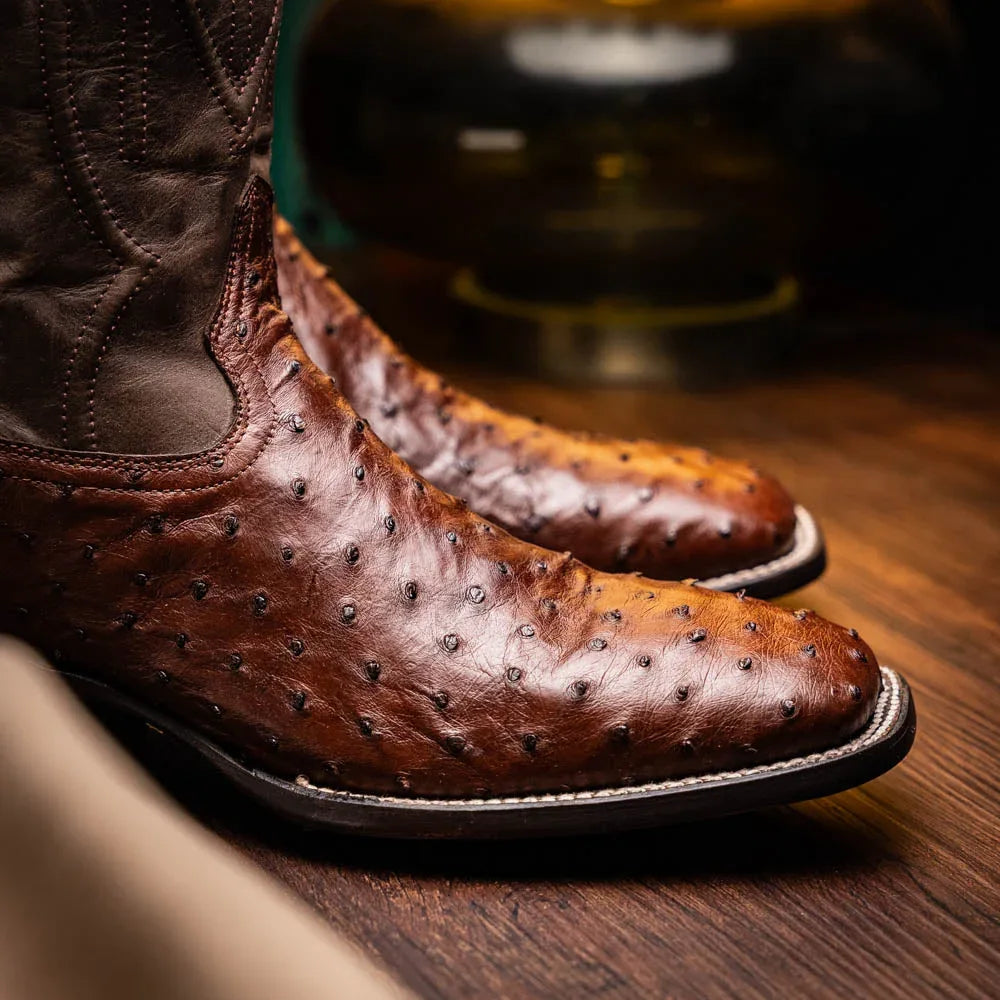 Side view of man walking in brown ostrich leather cowboy boots with square toe