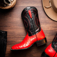 Lifestyle shot showing Alabama Red boots paired with rolled-up jeans in natural setting.