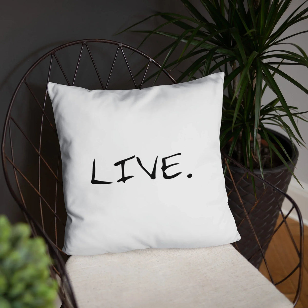 White pillow resting on a couch with a light-colored blanket in a softly lit room