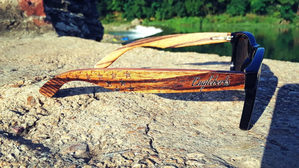 Profile view of Zebrawood sunglasses resting against a white backdrop.