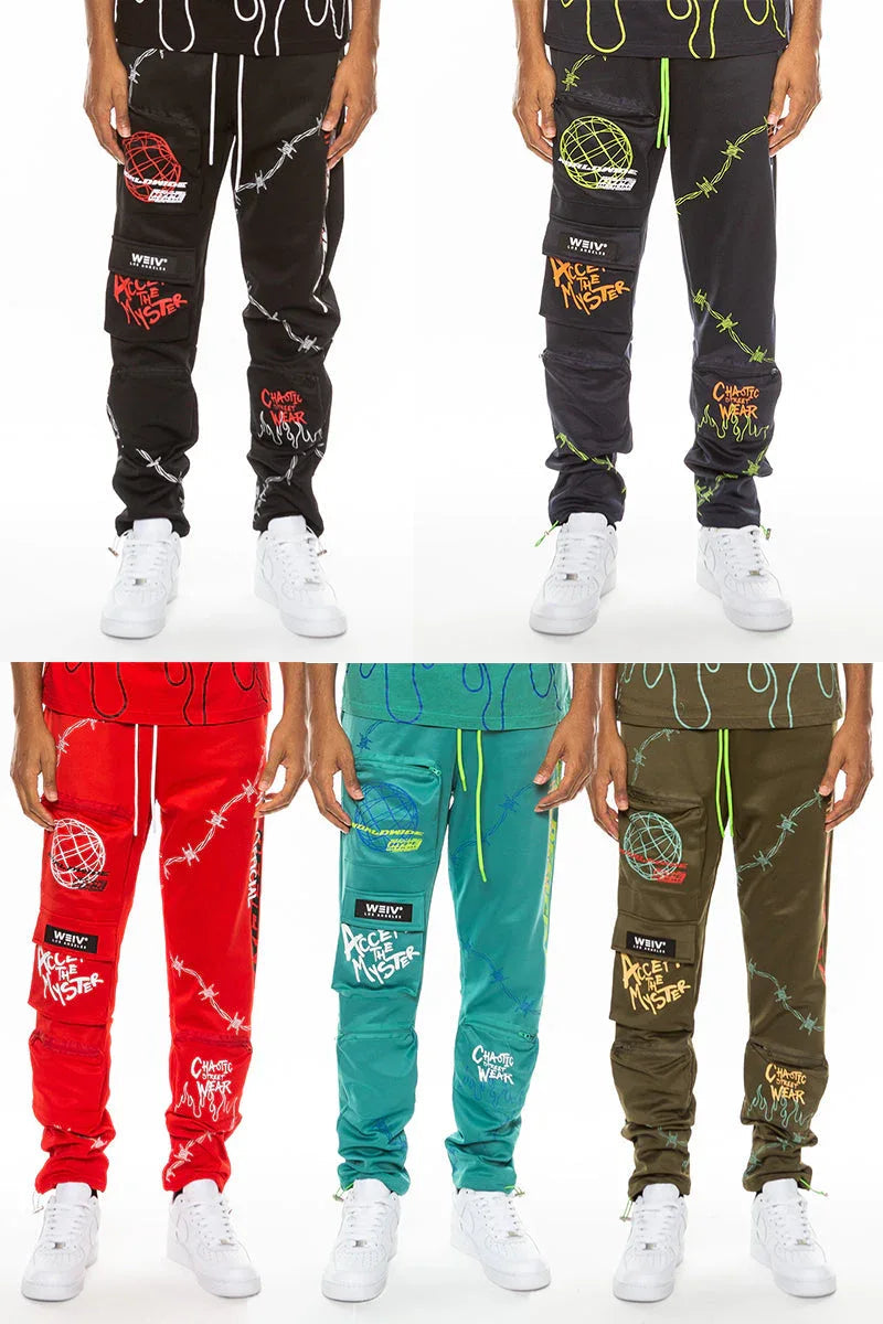 Front view of men's black track pants with digital print, elastic waist, and zippered pouch pockets