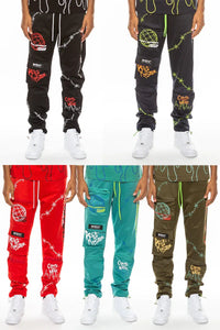 Front view of men's black track pants with digital print, elastic waist, and zippered pouch pockets