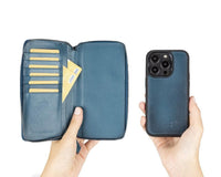 Leisure desk setup with black iPhone 14 leather wallet case, keys, and casual accessories beside laptop.