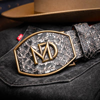 Man adjusting ARKANSAS python western belt, showing textured python pattern and vintage buckle.
