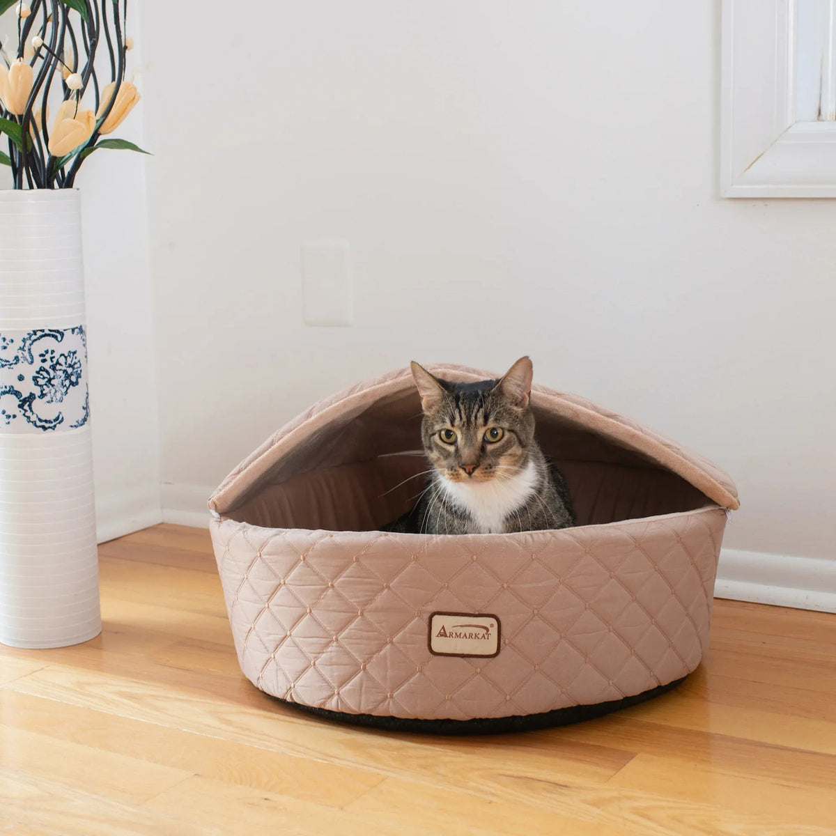 Light apricot colored Armarkat cat bed with soft velvet texture, raised sides, and plush cushioned interior