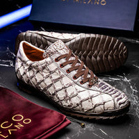 Lifestyle photo of person wearing Batistini sneakers standing on textured ground outdoors.