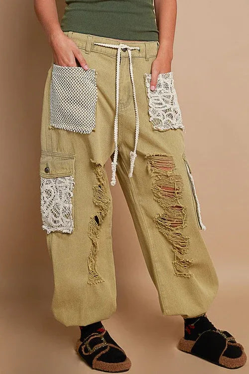 Side view of distressed washed jeans showing frayed edges and crochet accents.