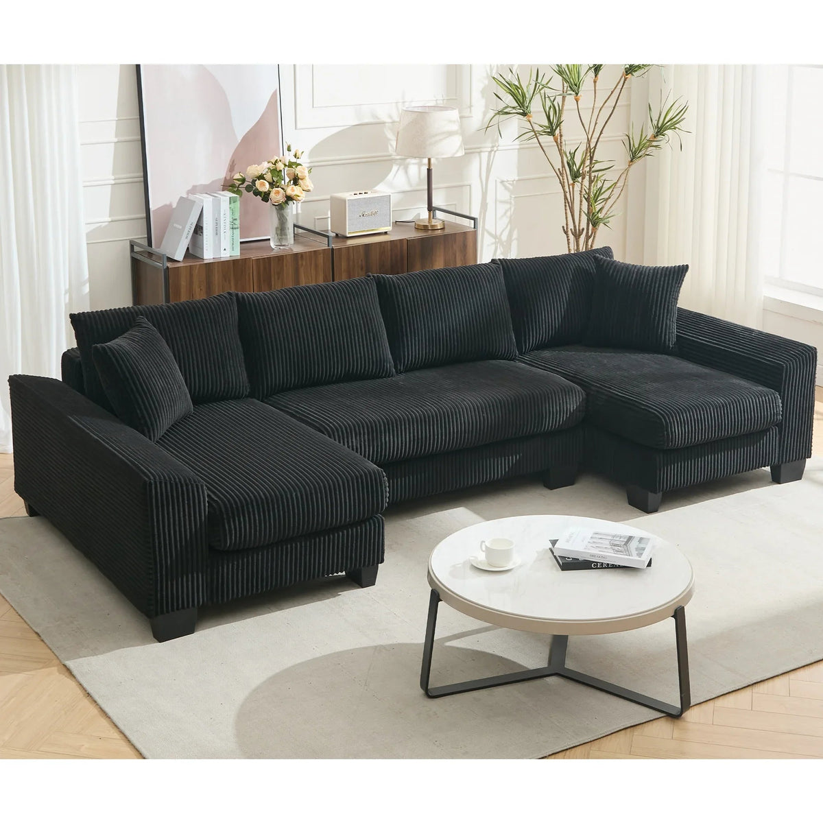 Large black U-shaped sleeper sofa with corduroy upholstery, pull-out bed, and plush seating for four.