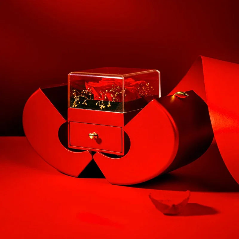 Close-up of handcrafted artificial rose inside red apple-shaped jewelry box.