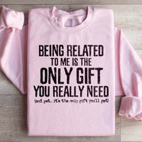 Light pink sweatshirt featuring the quote 'Being Related To Me Is The Only Gift You Really Need' on front.