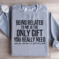 Light grey sweatshirt with text 'Being Related To Me Is The Only Gift You Really Need' in bold lettering.