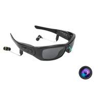 Black camcorder sunglasses with built-in camera and headphones on white background.