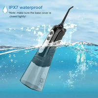 Dental water flosser held in hand illustrating compact, travel-friendly size.