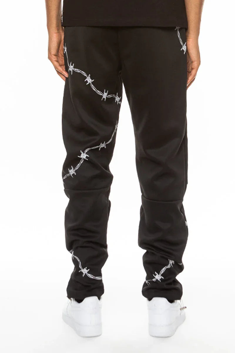 Close-up of black track pants fabric and zipper pocket on men's athletic pants