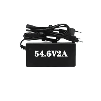 Black power charger plugged in, designed for charging the Blue 48V 62Ah lithium battery.