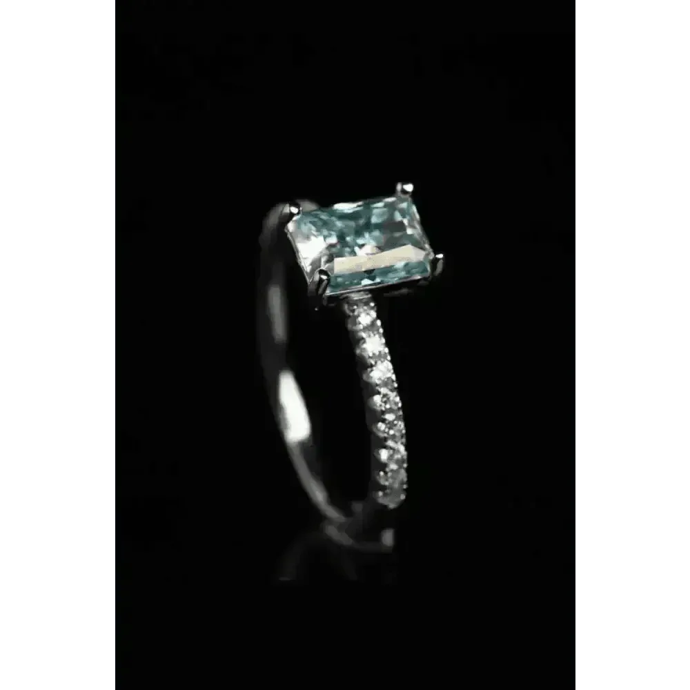 Blue gemstone ring featured on white surface with clear focus on stone