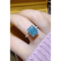 Top view of blue moissanite gemstone ring on black fabric background