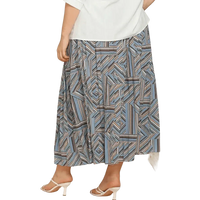 Model wearing blue geometric pleated skirt in deep teal, styled with a white top and black shoes.