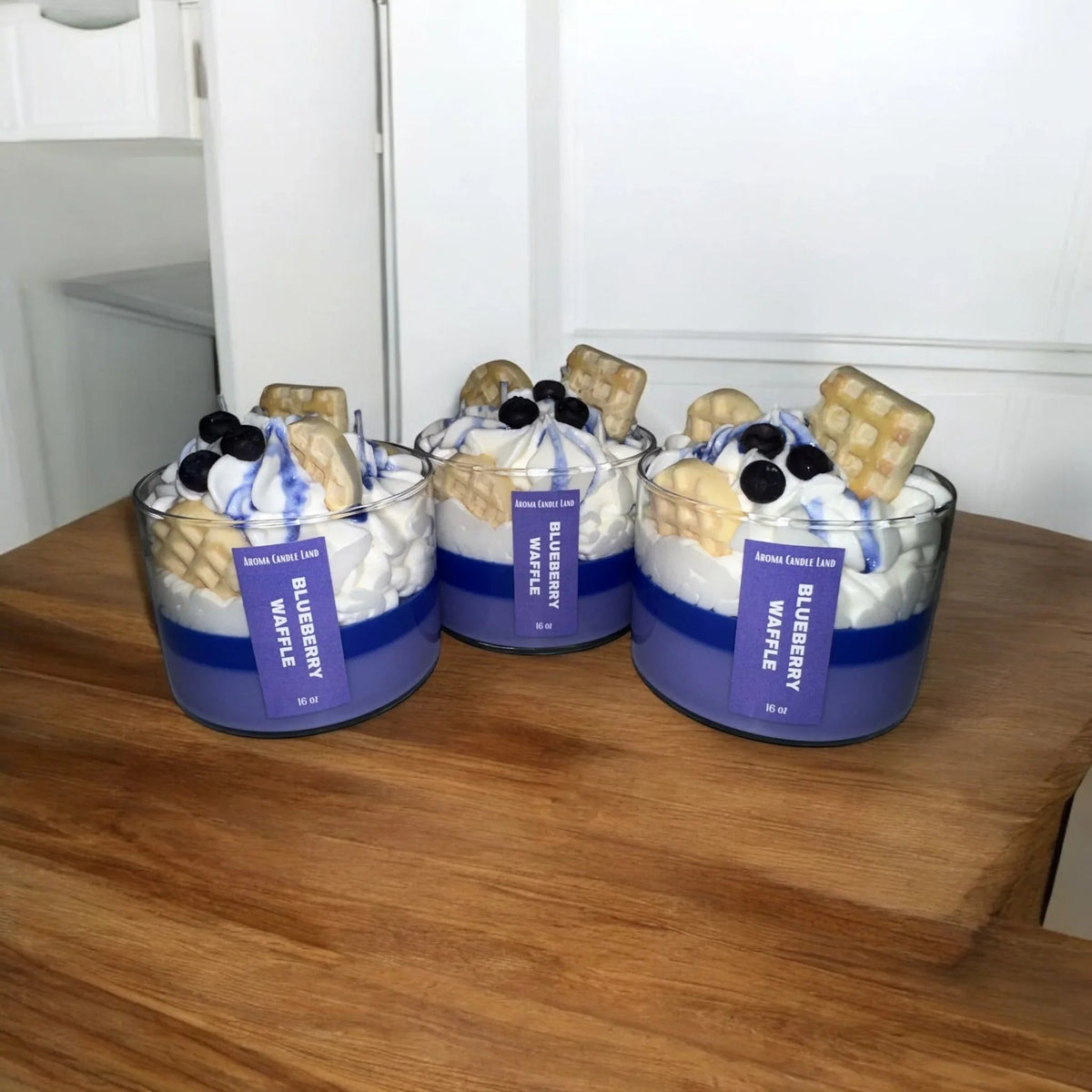Group of Blueberry Waffle scent candles arranged together on a rustic wooden surface.
