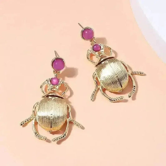 Close-up of gold-plated Bohemia earrings shaped like cute beetles with diamond accents.