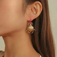 Front view of vintage style beetle-shaped gold-plated Bohemia earrings with intricate details.