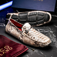 Lifestyle image of person wearing natural python driving shoes with rolled-up jeans outdoors.