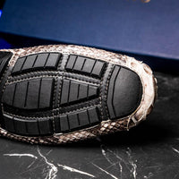 Man walking on pavement wearing natural python python driving shoes, emphasizing stylish everyday wear.