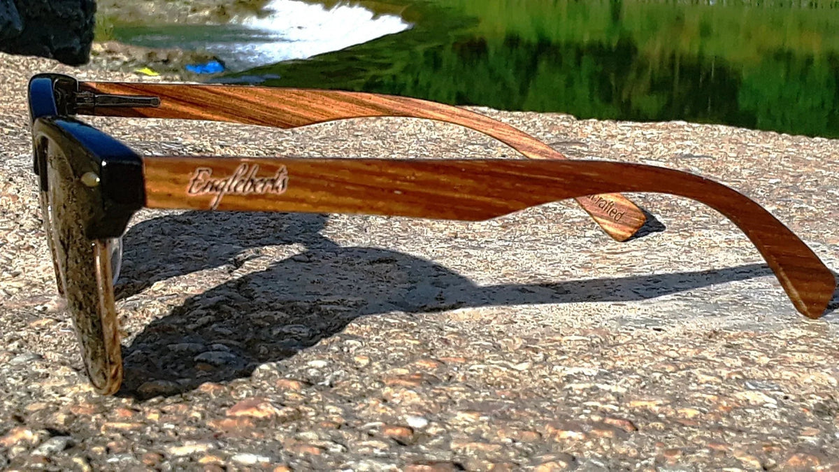 Side profile of walnut wood sunglasses displaying smooth temple and lens curvature.
