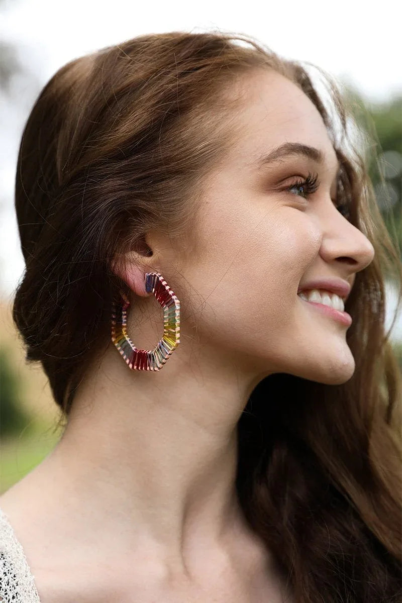 Brightly colored raffia hoop earrings displayed flat, highlighting their circular shape and rich textures.